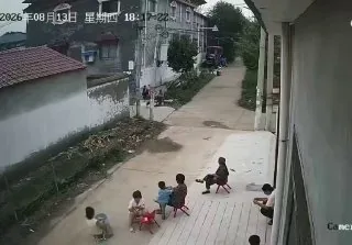 8月13日 河南，监控拍下惊险一幕。两名老人带着孩子在家门口路边坐着，还有小孩直接坐在路中间玩耍闲聊。